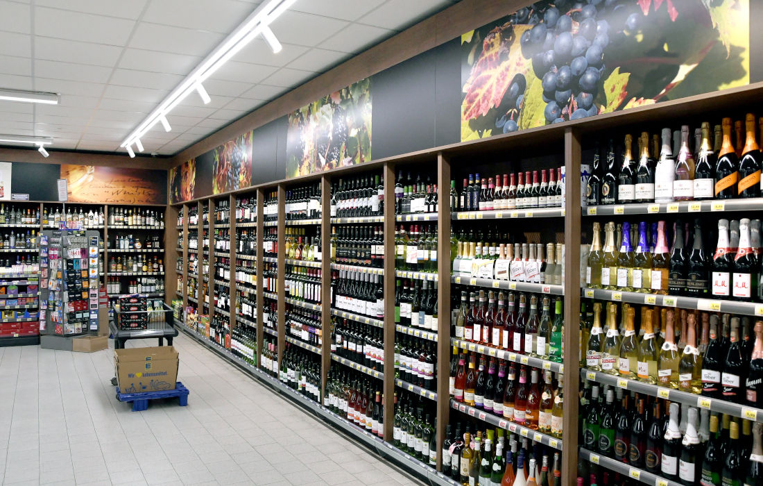 Mann und Frau wählen alkoholische Getränke im Supermarkt